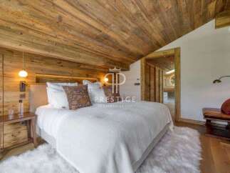 Experience luxury in this stunning bedroom featuring a rustic wooden ceiling and walls, creating a warm and inviting atmosphere.