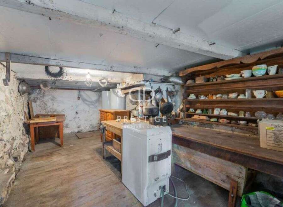 Explore the rustic charm of this unique property, featuring a spacious basement with exposed stone walls and wooden floors.