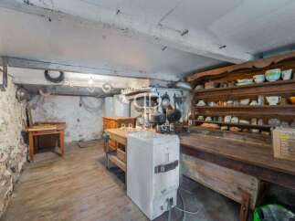 Explore the rustic charm of this unique property, featuring a spacious basement with exposed stone walls and wooden floors.