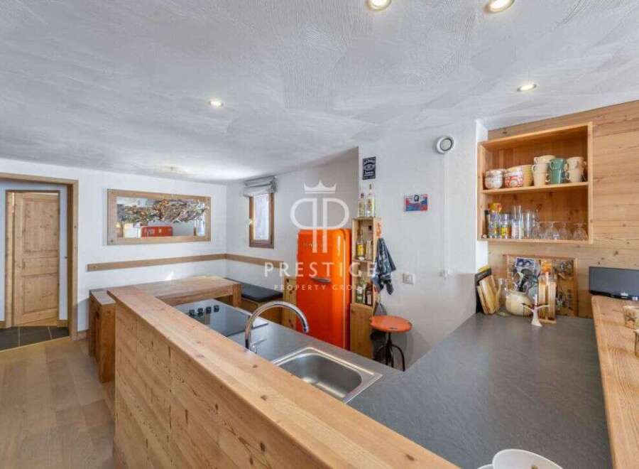 Discover this charming kitchen with a retro orange refrigerator, perfect for a cozy chalet experience.