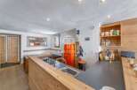 Discover this charming kitchen with a retro orange refrigerator, perfect for a cozy chalet experience.