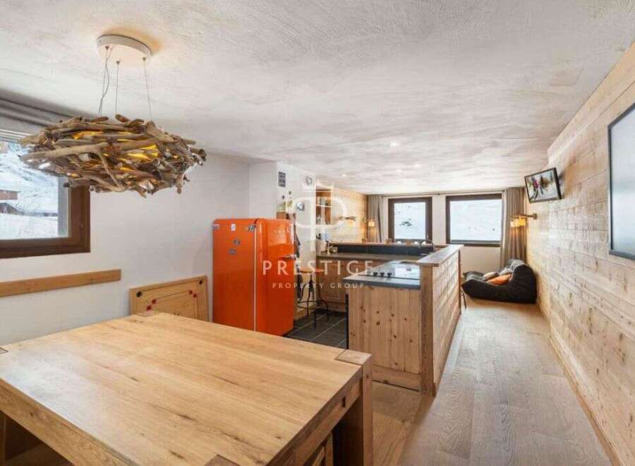 Discover the charm of this cozy property, featuring a rustic wooden interior and a unique driftwood chandelier.