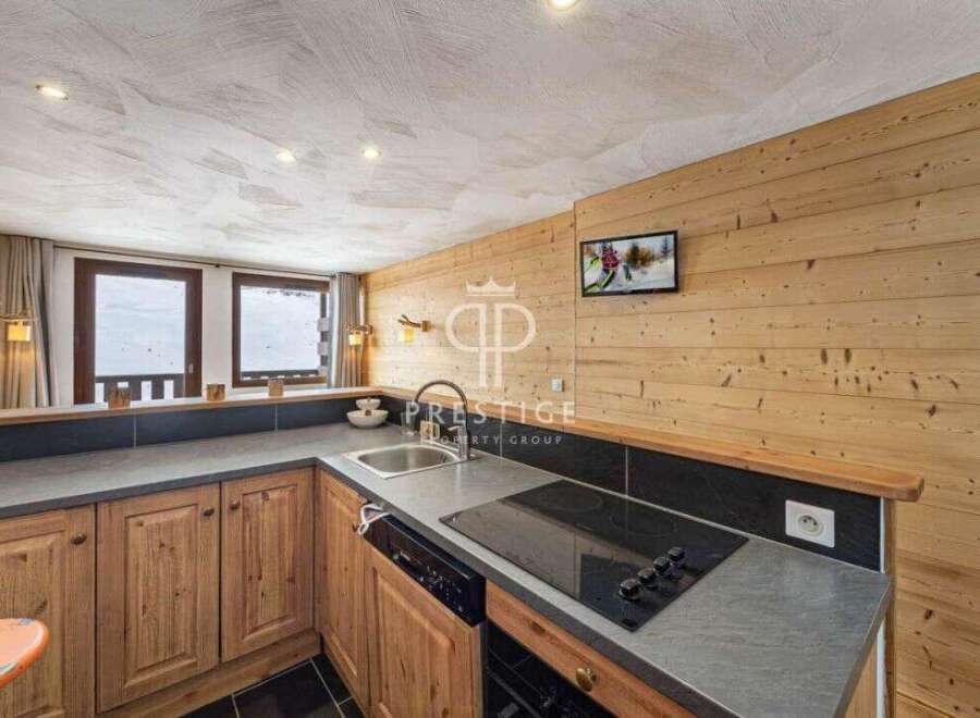 Discover a cozy kitchen with wooden cabinets and a sleek countertop, perfect for preparing meals.
