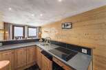 Discover a cozy kitchen with wooden cabinets and a sleek countertop, perfect for preparing meals.