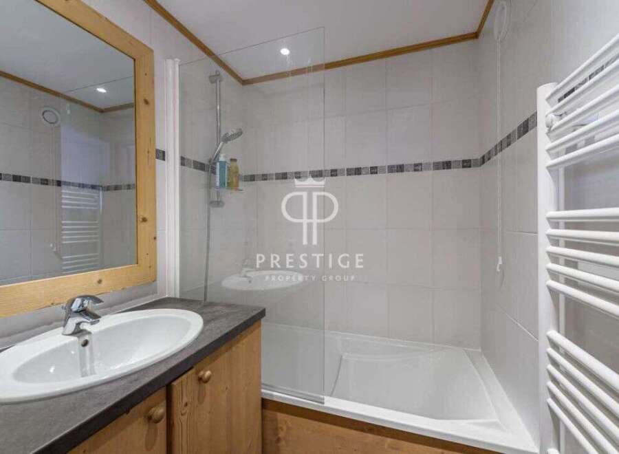 Discover a stylish bathroom featuring a sleek sink and a modern shower.