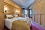 Experience the warmth of this cozy bedroom, featuring stunning wooden accents and a comfortable bed.