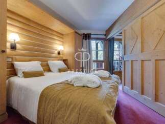 Experience the warmth of this cozy bedroom, featuring stunning wooden accents and a comfortable bed.