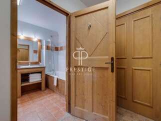 Discover a charming bathroom with a rustic wooden door, offering a warm and inviting atmosphere.