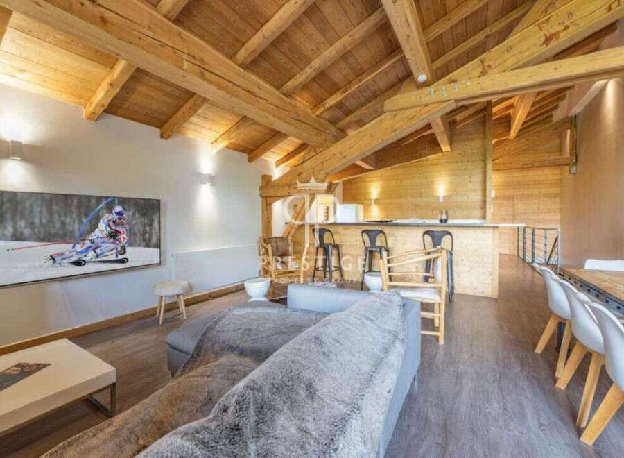 Experience luxury living in this stunning property, featuring a cozy living room with a plush sofa and a large TV.
