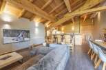 Experience luxury living in this stunning property, featuring a cozy living room with a plush sofa and a large TV.