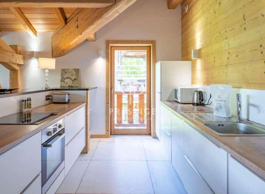 Discover the charm of this stunning kitchen, featuring a modern design with sleek white cabinetry and warm wooden accents.