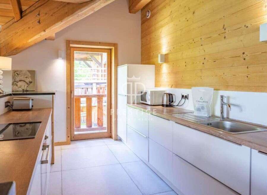 Discover a charming kitchen with a rustic wooden ceiling and walls, creating a warm and inviting atmosphere.