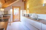 Discover a charming kitchen with a rustic wooden ceiling and walls, creating a warm and inviting atmosphere.
