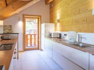 Discover a charming kitchen with a rustic wooden ceiling and walls, creating a warm and inviting atmosphere.