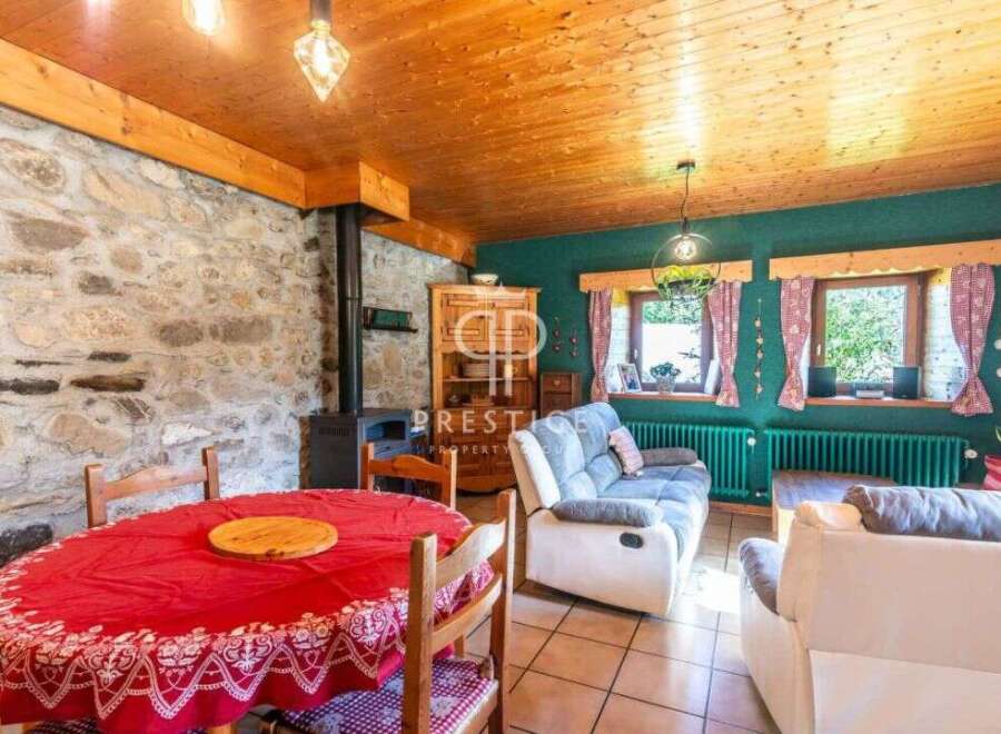Charming rustic living space with exposed stone walls and a cozy fireplace.