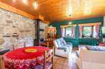 Charming rustic living space with exposed stone walls and a cozy fireplace.