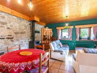 Charming rustic living space with exposed stone walls and a cozy fireplace.