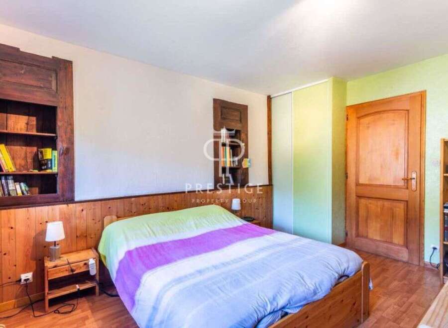 Discover the charm of this cozy bedroom, featuring a warm wooden interior and a comfortable bed.