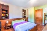 Discover the charm of this cozy bedroom, featuring a warm wooden interior and a comfortable bed.