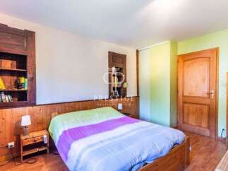 Discover the charm of this cozy bedroom, featuring a warm wooden interior and a comfortable bed.