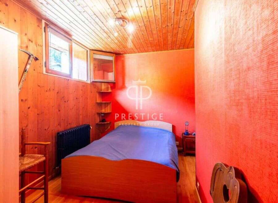 Discover a cozy bedroom with a unique wooden ceiling and walls, creating a warm and inviting atmosphere.