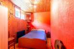 Discover a cozy bedroom with a unique wooden ceiling and walls, creating a warm and inviting atmosphere.