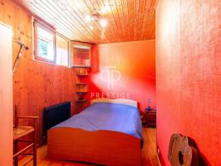 Discover a cozy bedroom with a unique wooden ceiling and walls, creating a warm and inviting atmosphere.