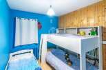 This charming bedroom features a cozy bunk bed, perfect for kids or guests.