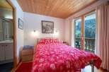 Cozy bedroom with a stunning view! This charming space features a comfortable bed with a vibrant red floral duvet, perfect for a relaxing stay.