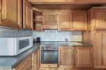 Discover the charm of this cozy kitchen, featuring warm wooden cabinetry and a functional layout.