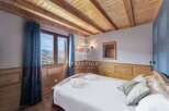 Discover the charm of this cozy bedroom, featuring a stunning wooden ceiling and walls that exude warmth.