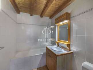 Discover this charming bathroom featuring a wooden ceiling and a stylish vanity.
