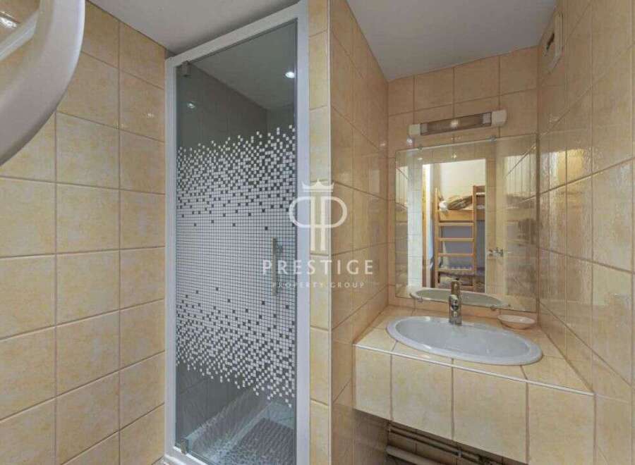 Discover a stylish bathroom featuring a modern shower enclosure and a sleek sink.