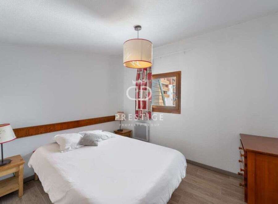 Discover a cozy bedroom with a comfortable bed and a stylish lamp.