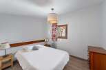 Discover a cozy bedroom with a comfortable bed and a stylish lamp.