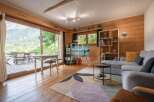 Experience the charm of this stunning property, featuring a cozy living room with wooden walls and a breathtaking mountain view.
