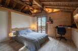 Discover the charm of this cozy bedroom, featuring a rustic wooden ceiling and walls that exude warmth.