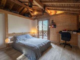 Discover the charm of this cozy bedroom, featuring a rustic wooden ceiling and walls that exude warmth.