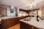 Discover luxury living in this stunning kitchen! Featuring sleek stainless steel appliances, rich wooden cabinetry, and a modern design, this space is perfect for both cooking and entertaining.