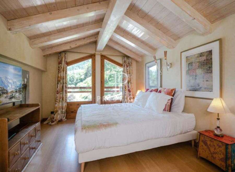 Experience the charm of this cozy bedroom with its rustic wooden ceiling and inviting ambiance.