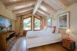Experience the charm of this cozy bedroom with its rustic wooden ceiling and inviting ambiance.