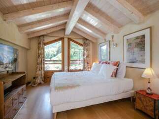 Experience the charm of this cozy bedroom with its rustic wooden ceiling and inviting ambiance.