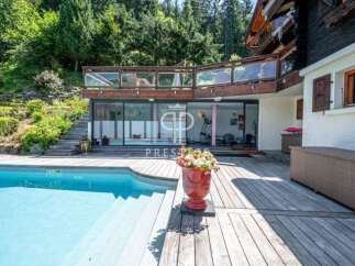 Discover luxury living at this stunning property! Enjoy a refreshing dip in the inviting pool, surrounded by a spacious wooden deck.
