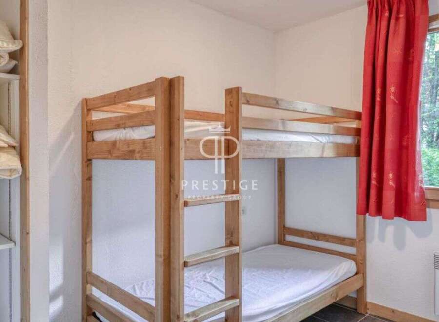 Discover a cozy bedroom featuring a charming wooden bunk bed, perfect for accommodating guests or family.