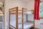 Discover a cozy bedroom featuring a charming wooden bunk bed, perfect for accommodating guests or family.