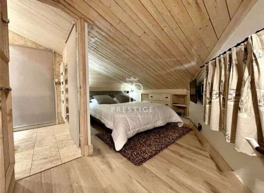 Discover the charm of this cozy bedroom with its unique wooden sloped ceiling and walls.