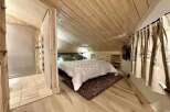 Discover the charm of this cozy bedroom with its unique wooden sloped ceiling and walls.