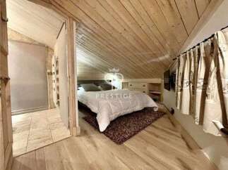 Discover the charm of this cozy bedroom with its unique wooden sloped ceiling and walls.