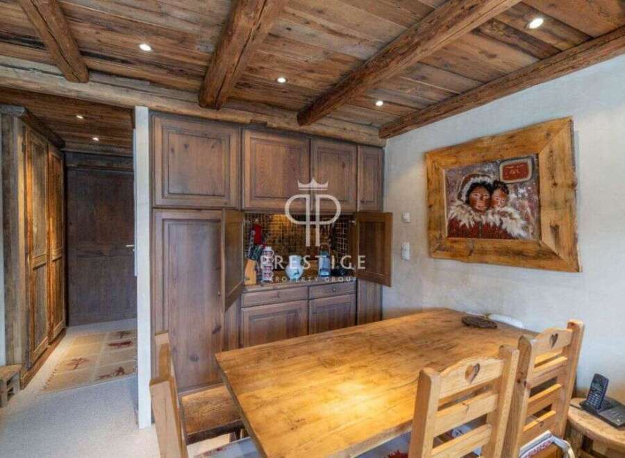 Discover rustic charm in this stunning property, featuring a warm wooden dining area perfect for gatherings.