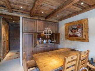 Discover rustic charm in this stunning property, featuring a warm wooden dining area perfect for gatherings.
